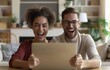 © Georgii - Happy couple celebrating success while watching something exciting on a tablet at home