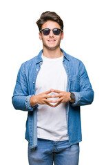 Sticker - Young handsome man wearing sunglasses over isolated background Hands together and fingers crossed smiling relaxed and cheerful. Success and optimistic