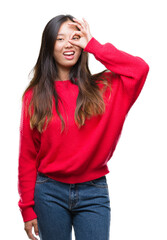 Poster - Young asian woman wearing winter sweater over isolated background doing ok gesture with hand smiling, eye looking through fingers with happy face.