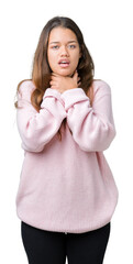 Young beautiful brunette woman wearing pink winter sweater over isolated background shouting and suffocate because painful strangle. Health problem. Asphyxiate and suicide concept.