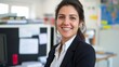 © Art Genie - Female HR manager wearing a formal suit, smiling confidently in a corporate office with documents and computers, highlighting expertise in human resources and professional business attire
