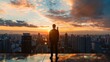 © Bundi - An assured businessman stands on the roof of a building watching the silhouette of the cityscape as it comes to dusk