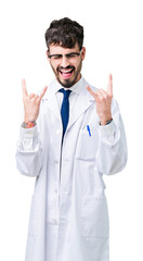 Wall Mural - Young professional scientist man wearing white coat over isolated background shouting with crazy expression doing rock symbol with hands up. Music star. Heavy concept.