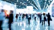© Naknakhone - A blurred photo of an international business exhibition, with many elegantly dressed people walking around the floor and holding brochures. copy space for text.