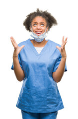 Wall Mural - Young afro american doctor woman over isolated background crazy and mad shouting and yelling with aggressive expression and arms raised. Frustration concept.