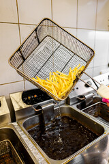 Wall Mural - A busy commercial kitchen with a deep fryer cooking French fries