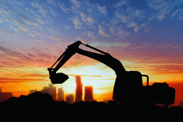 Wall Mural - Crawler excavators silhouette are digging the soil in the construction site. on  sunset background