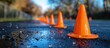 © MBRAMO - Orange Cones on a Wet Asphalt Road