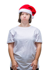 Sticker - Young adult woman with down syndrome wearing christmas hat over isolated background with serious expression on face. Simple and natural looking at the camera.