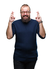 Wall Mural - Young caucasian hipster man wearing sunglasses over isolated background smiling crossing fingers with hope and eyes closed. Luck and superstitious concept.