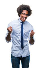 Poster - Afro american business man wearing glasses over isolated background very happy and excited doing winner gesture with arms raised, smiling and screaming for success. Celebration concept.