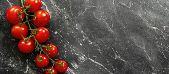Leinwandbilder - Top view of vibrant red tomatoes on a stylish black stone board with copy space image