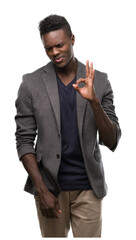 Wall Mural - Young african american man wearing a jacket doing ok sign with fingers, excellent symbol