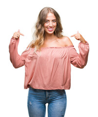 Wall Mural - Beautiful young blonde woman over isolated background looking confident with smile on face, pointing oneself with fingers proud and happy.