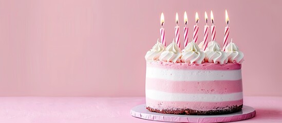 Poster - Pink and white striped buttercream adorned birthday cake with numerous candles on a pink backdrop perfect for a celebratory copy space image