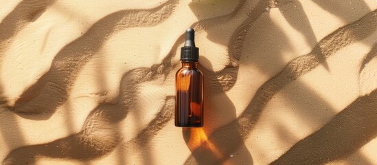 Poster - Beauty cosmetic face serum in a brown glass bottle with a pipette placed on a sandy natural background effective for hydrating the skin showcasing a copy space image