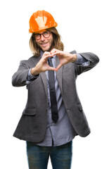 Sticker - Young handsome architec man with long hair wearing safety helmet over isolated background smiling in love showing heart symbol and shape with hands. Romantic concept.