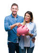 © Krakenimages.com - Young couple in love holding piggy bank over isolated background with a happy face standing and smiling with a confident smile showing teeth