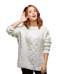 Poster - Young beautiful woman over isolated background wearing winter sweater smiling with hand over ear listening an hearing to rumor or gossip. Deafness concept.