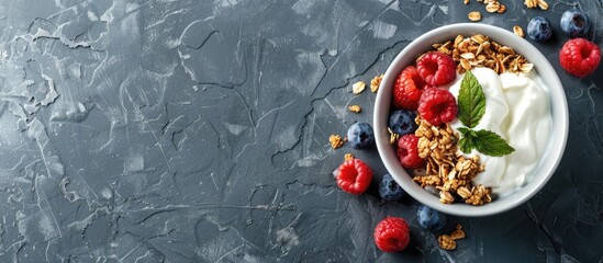 Aufkleber - Top view of a healthy breakfast consisting of granola with berries and yogurt on a grey stone background with copy space image available
