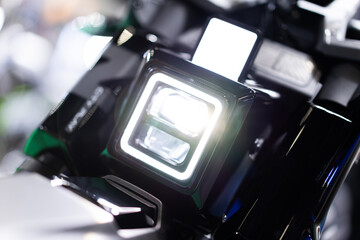 The headlights of electric motorcycles are LED lights, modern technology. environmentally friendly Focus on a specific point On the background bokeh light