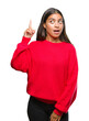 © Krakenimages.com - Young beautiful arab woman wearing winter sweater over isolated background pointing finger up with successful idea. Exited and happy. Number one.