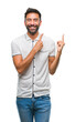 © Krakenimages.com - Adult hispanic man over isolated background smiling and looking at the camera pointing with two hands and fingers to the side.