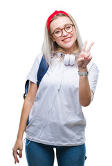 Wall Mural - Young blonde student woman wearing glasses and backpack over isolated background smiling with happy face winking at the camera doing victory sign. Number two.