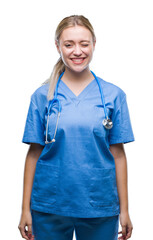 Canvas Print - Young blonde surgeon doctor woman over isolated background winking looking at the camera with sexy expression, cheerful and happy face.