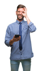 Canvas Print - Young hadsome man texting sending message using smartphone over isolated background with happy face smiling doing ok sign with hand on eye looking through fingers