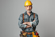 © 수동 김 - Stylish middle-aged man in hard hat and tool belt, arms crossed against gray background with space for copy. Confident worker or carpenter posing