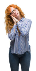 Wall Mural - Young redhead bussines woman sleeping tired dreaming and posing with hands together while smiling with closed eyes.