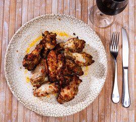 Wall Mural - Plate with fried chicken wings on wooden table background