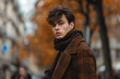 © Sergio - Young man in brown plaid coat standing on city street during autumn