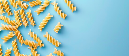 Aufkleber - Trofie pasta uncooked on a light blue backdrop top down view with copy space image