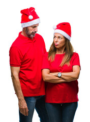 Sticker - Middle age hispanic couple wearing christmas hat over isolated background skeptic and nervous, disapproving expression on face with crossed arms. Negative person.