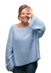 Sticker - Middle age senior hispanic woman wearing winter sweater over isolated background doing ok gesture with hand smiling, eye looking through fingers with happy face.