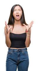 Wall Mural - Young asian woman over isolated background crazy and mad shouting and yelling with aggressive expression and arms raised. Frustration concept.