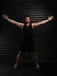 © Sanc/peopleimages.com - Arms, open and man with portrait in gym for fitness pr exercise, healthy living and serious for wellbeing or wellness. Person, black background and determined for physical cardio or muscle strength.
