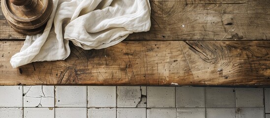 Sticker - An overhead shot of an old wooden table covered with a linen kitchen towel or napkin on a kitchen countertop with a rustic tablecloth perfect for a copy space image