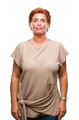 Poster - Atrractive senior caucasian redhead woman over isolated background with serious expression on face. Simple and natural looking at the camera.