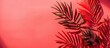 © vxnaghiyev - Tropical vacation concept featuring red palm fronds set against a coral background with copy space image