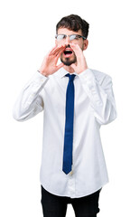 Wall Mural - Young handsome business man wearing glasses over isolated background Shouting angry out loud with hands over mouth