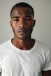 © Nica - hyper realistic photograph of a handsome african american man in a white t-shirt looking directly at the camera.