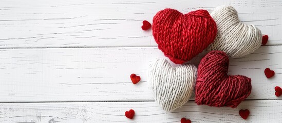 Poster - Valentine s Day background featuring artisanal heart shaped toys on a white wooden backdrop with room for copy space image