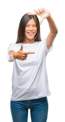 Canvas Print - Young asian woman over isolated background smiling making frame with hands and fingers with happy face. Creativity and photography concept.