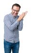 © Krakenimages.com - Handsome middle age elegant senior man wearing glasses over isolated background Clapping and applauding happy and joyful, smiling proud hands together