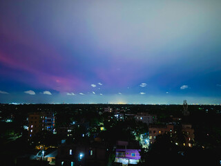 night city landscape with rainbow sky and white clouds