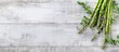 © Ilgun - Fresh green asparagus sprouts on a white wooden surface with copy space image