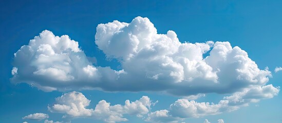 Wall Mural - puffy white clouds floating in a clear blue sky with ample copy space image